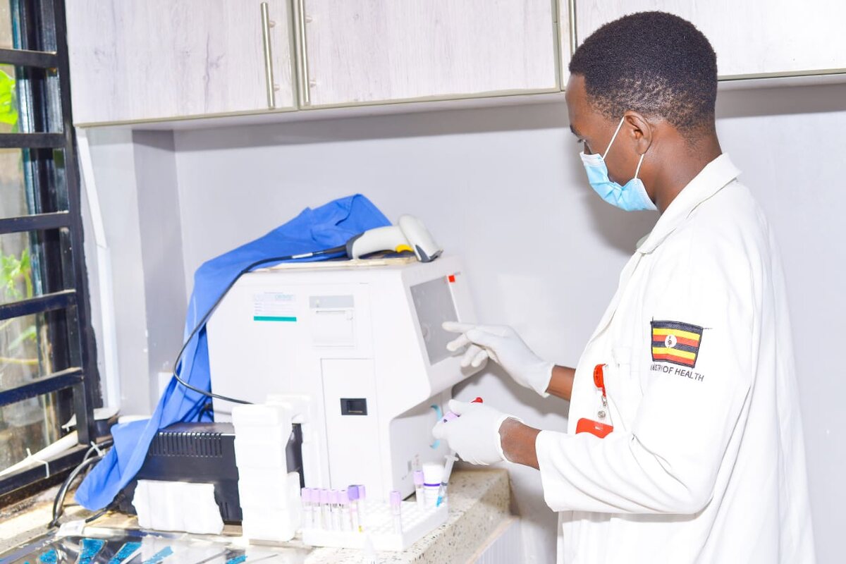 Laboratory technician operating a haematology analyzer at Entebbe Medical Chambers